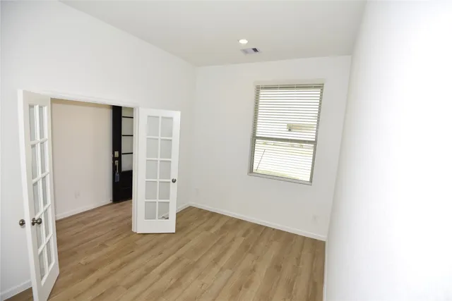 a view of empty room with wooden floor