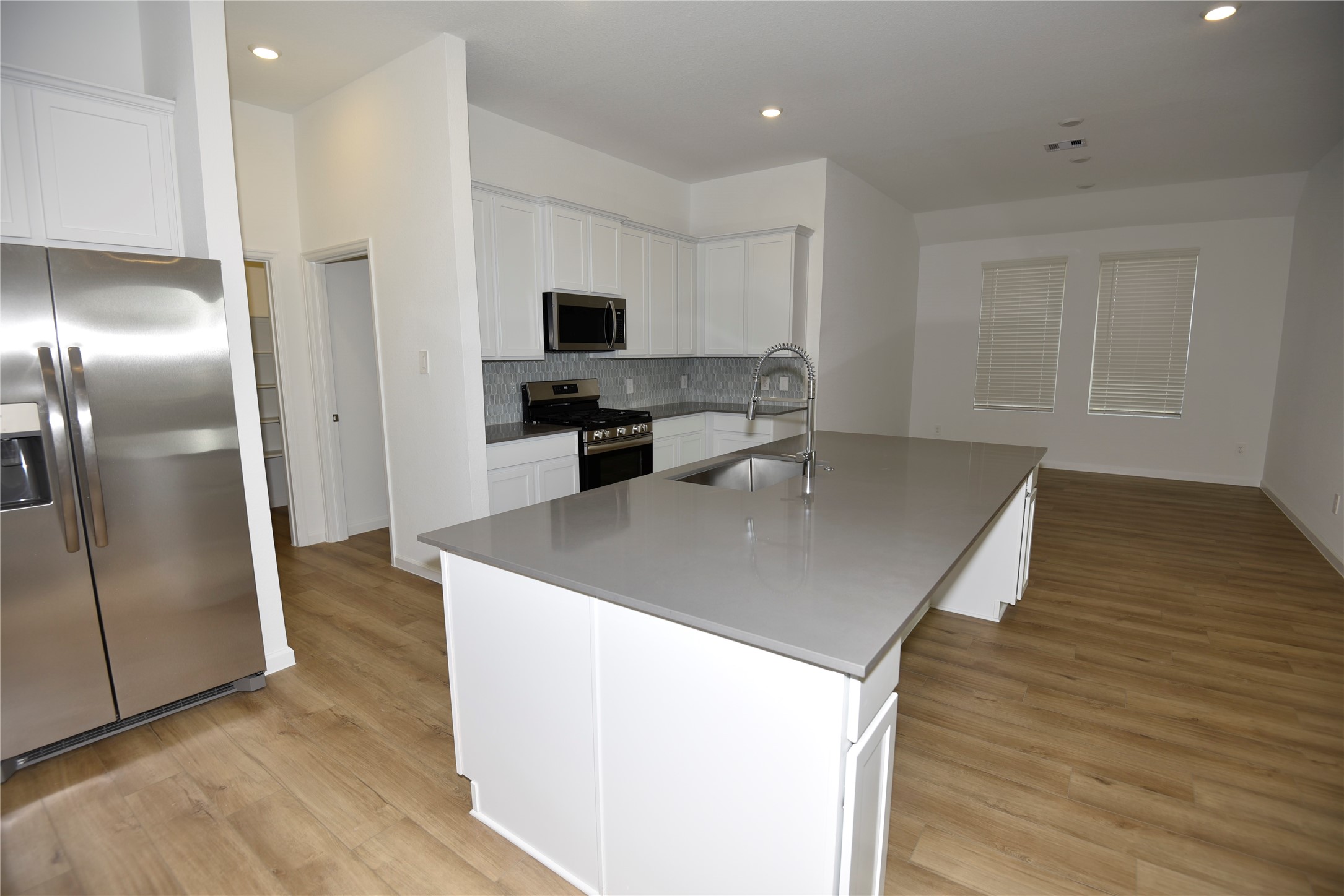 15524 Leopard Lily Lane Conroe, TX 77302 - Photo 9 of 47 a kitchen with stainless steel appliances granite countertop a sink a microwave a refrigerator and a stove