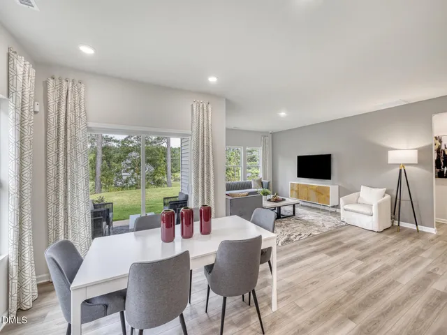 a kitchen with a sink a refrigerator and white cabinets with wooden floor