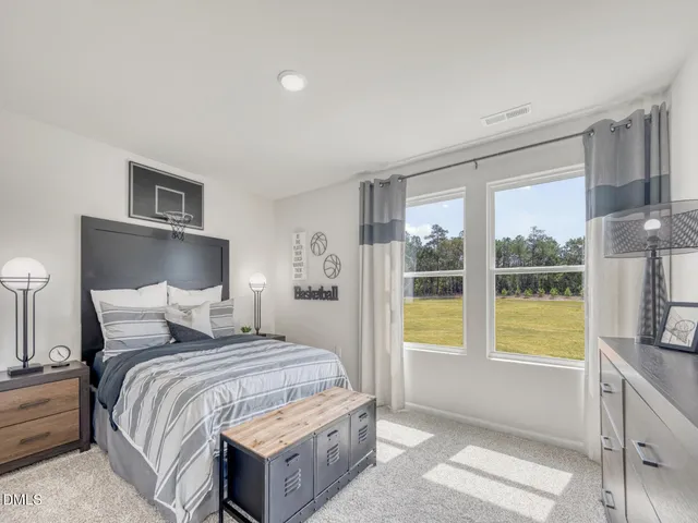 a bedroom with a bed a mirror and painting on the wall