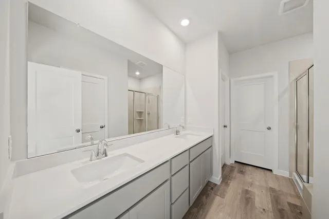 a bathroom with a sink double vanity granite tub shower and a mirror