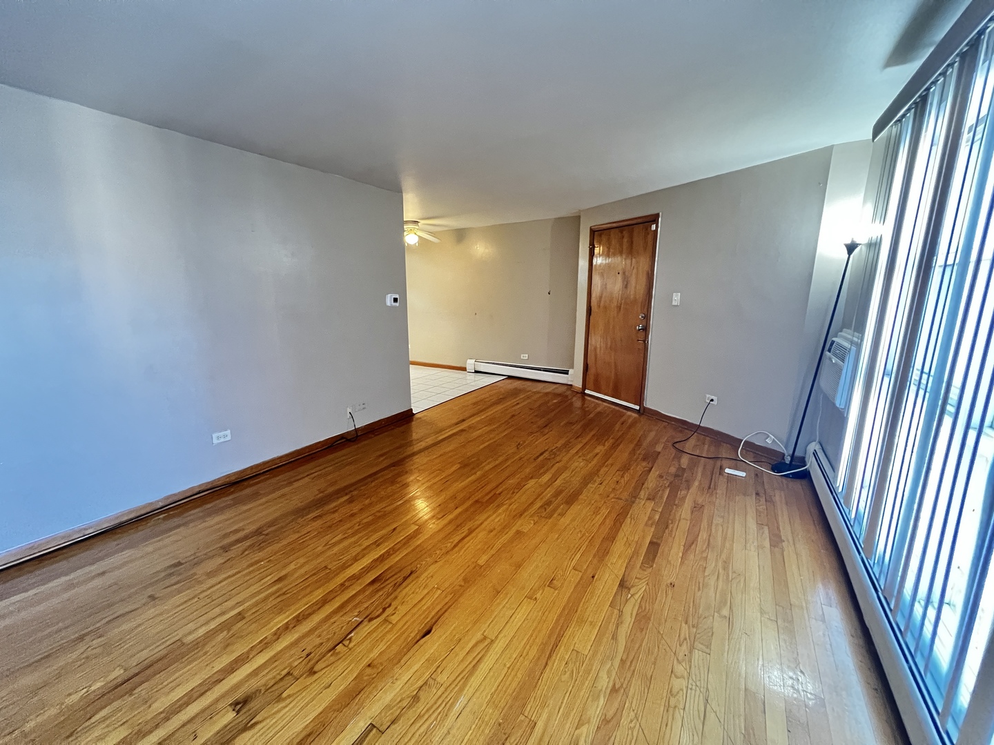 11903 Gregory Street, Unit 3 Blue Island, IL 60406 - Photo 6 of 9 a view of an empty room with wooden floor and a window