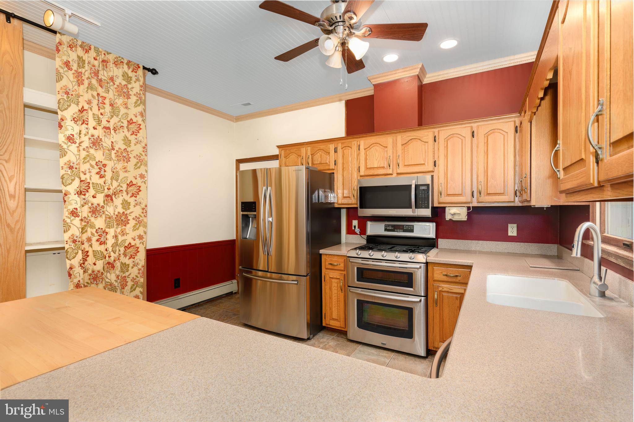 24029 Meadows Drive Ridgely, MD 21660 - Photo 13 of 39 a kitchen with stainless steel appliances a stove a microwave and a refrigerator
