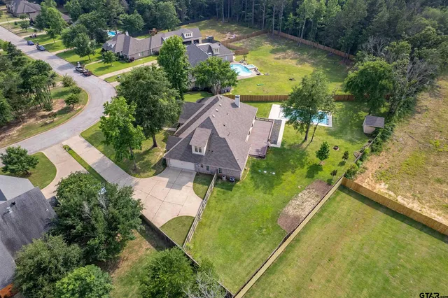 an aerial view of a house with swimming pool and garden