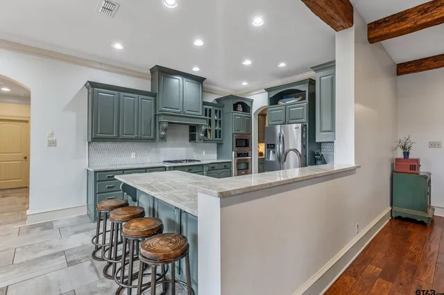 a kitchen with stainless steel appliances granite countertop a sink and a refrigerator