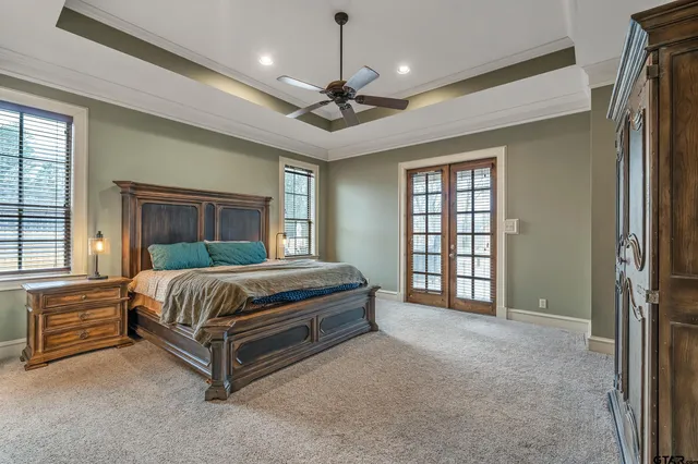 a spacious bedroom with a bed chandelier and a window