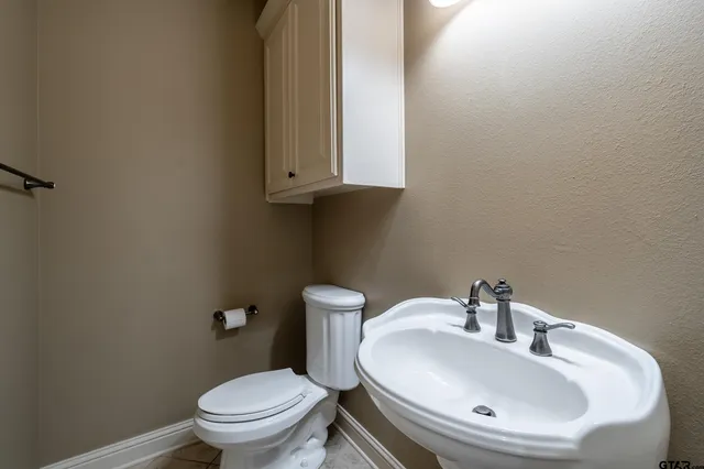 a bathroom with a sink a toilet and mirror