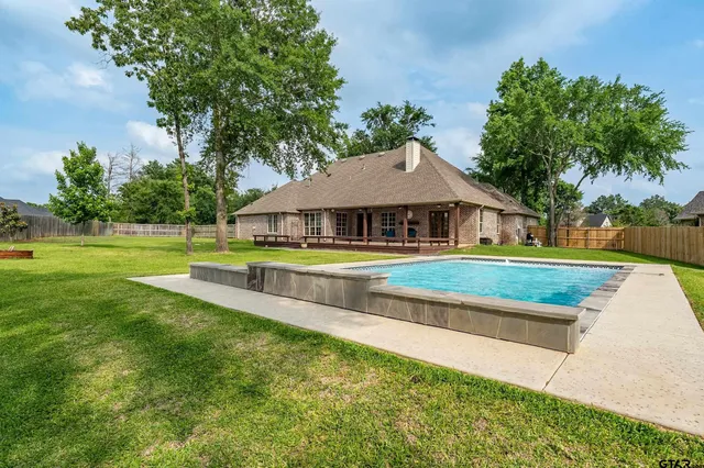 a view of pool with umbrella and trees around
