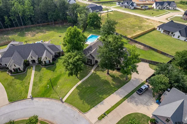 an aerial view of a house with swimming pool and a yard