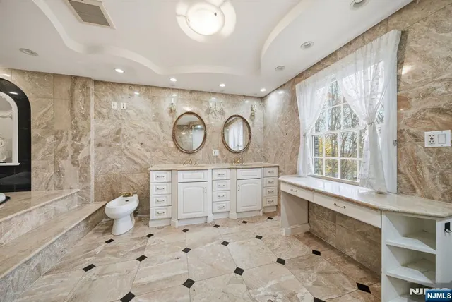 a bathroom with a granite countertop sink a toilet and a mirror