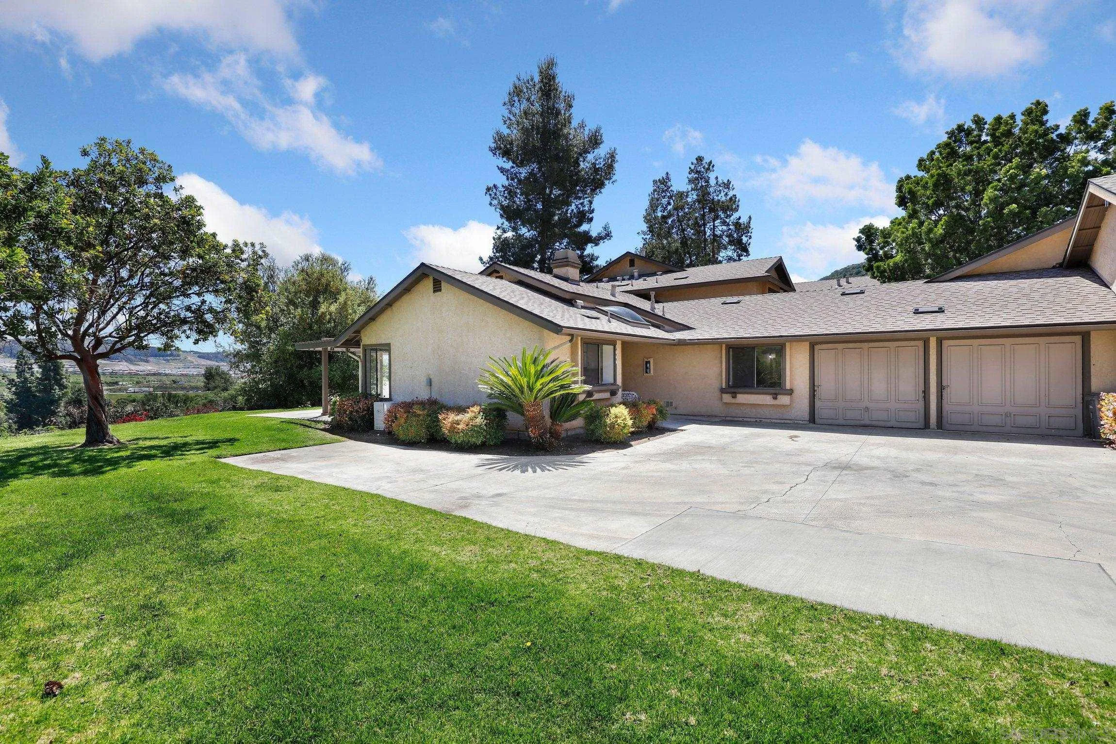 1666 Pala Lake Drive Fallbrook, CA 92028 - Photo 2 of 24 a front view of a house with a yard and a garage