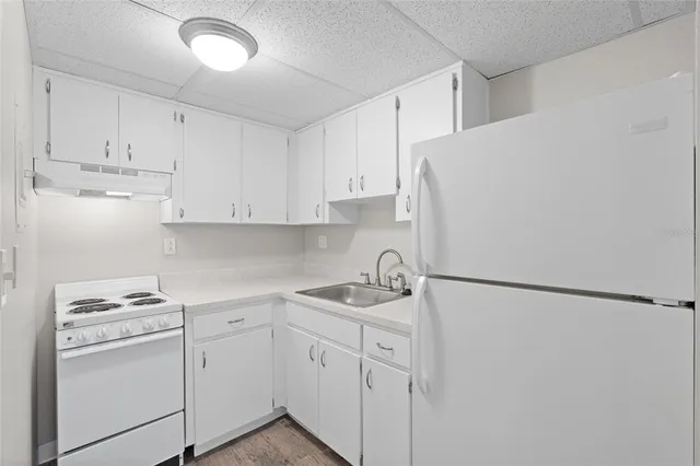 a kitchen with white cabinets and white appliances