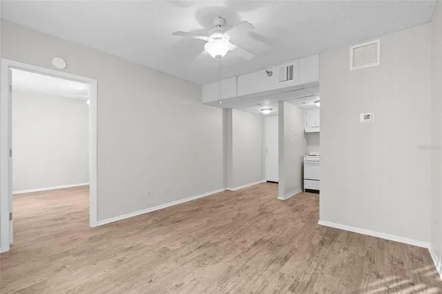a view of an empty room with a ceiling fan
