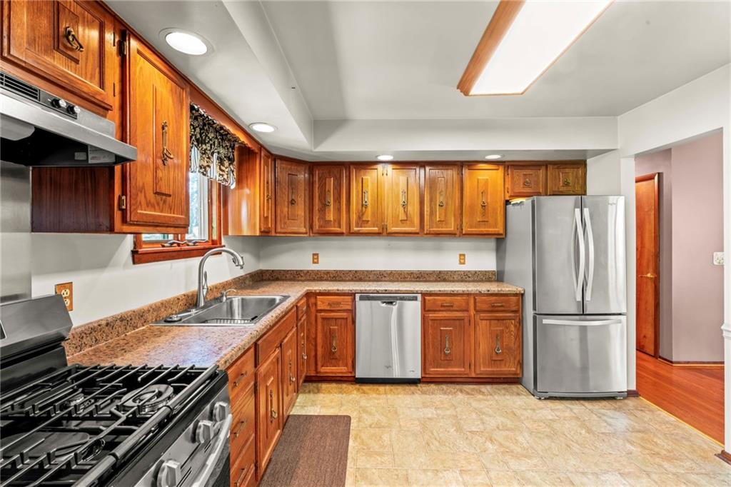 116 Jackson Circle McDonald, PA 15057 - Photo 14 of 33 a kitchen with stainless steel appliances granite countertop a refrigerator a sink dishwasher a stove and white countertops with wooden floor