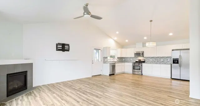 an empty room with windows and fireplace