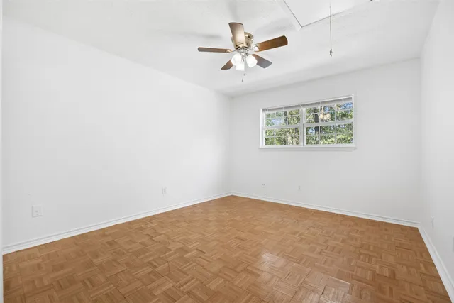 an empty room with window and ceiling fan