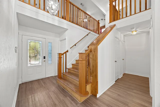 a view of front door with wooden floor and stairs