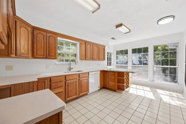 a large kitchen with kitchen island granite countertop a large window and white cabinets