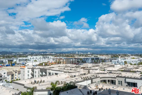a bedroom with a bed a chair and a large window
