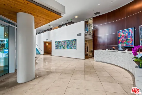 a view of a hallway with a couch and a painting on the wall