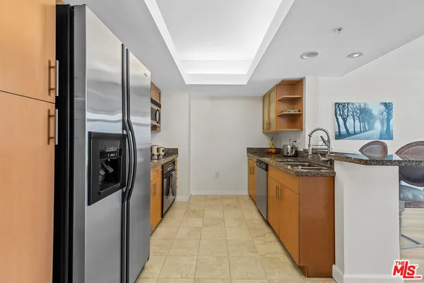 a kitchen with stainless steel appliances granite countertop a refrigerator and a stove