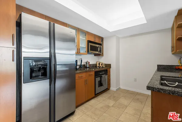 a kitchen with stainless steel appliances granite countertop a stove refrigerator and a microwave