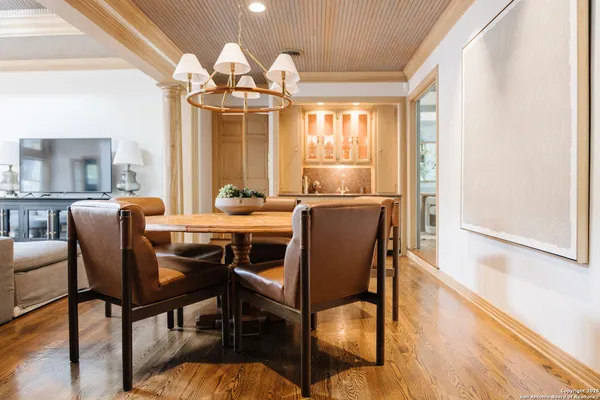 a dining room with furniture a chandelier and wooden floor