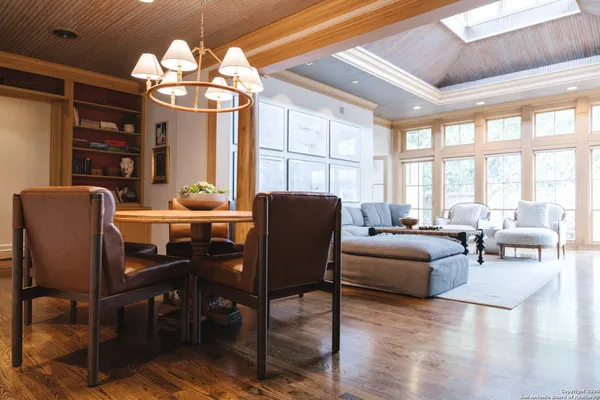 a dining room with furniture a chandelier and wooden floor