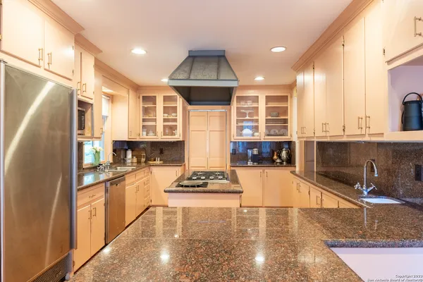 a kitchen with stainless steel appliances granite countertop a sink stove and refrigerator