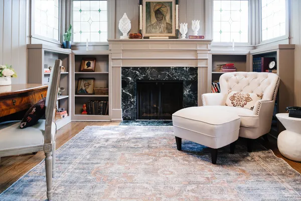 a living room with furniture a fireplace and a window