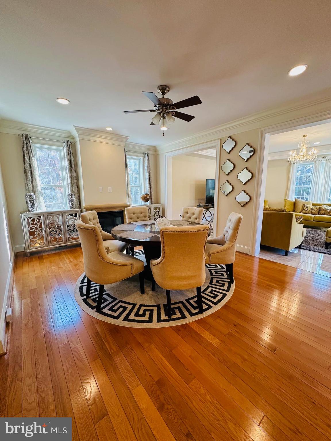 6413 Divine Street McLean, VA 22101 - Photo 15 of 60 a dining room with wooden floor a chandelier a glass table and chairs