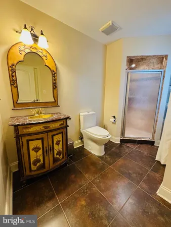 a bathroom with a granite countertop sink mirror vanity and toilet