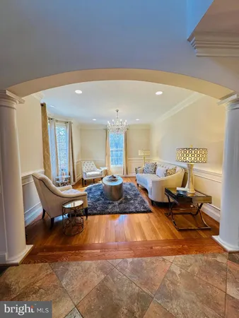 a dining room with wooden floor a chandelier a glass table and chairs