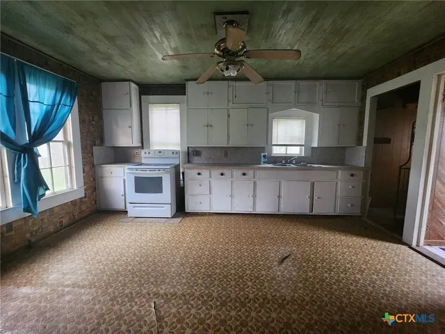 a kitchen with granite countertop a sink stainless steel appliances and cabinets
