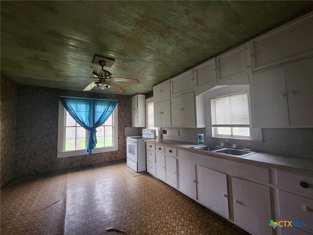 4955 Highway 119 Goliad, TX 77963 - Photo 7 of 7 a kitchen with granite countertop a sink stainless steel appliances cabinets and a window
