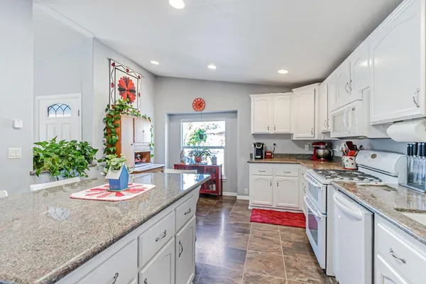 a kitchen with stainless steel appliances granite countertop sink stove top oven and cabinets