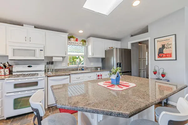 a kitchen with kitchen island a table and chairs in it