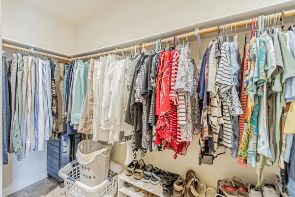 a view of walk in closet with clothes and shoes