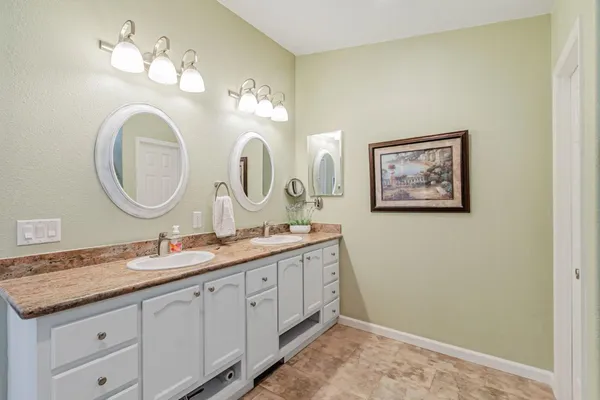 a bathroom with a double vanity sink and a mirror