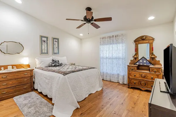 a bedroom with a bed and wooden floor
