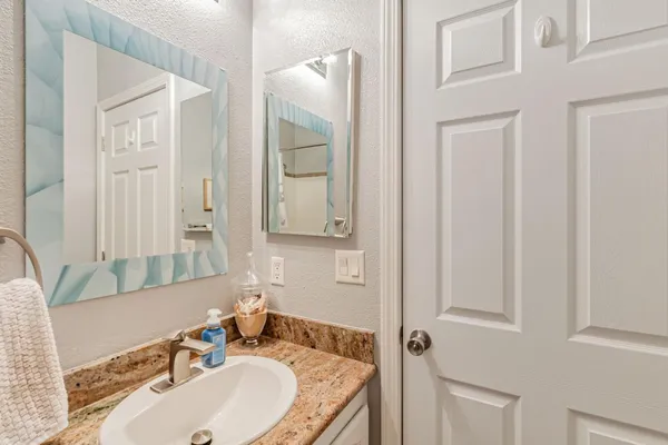 a bathroom with a granite countertop sink and a mirror
