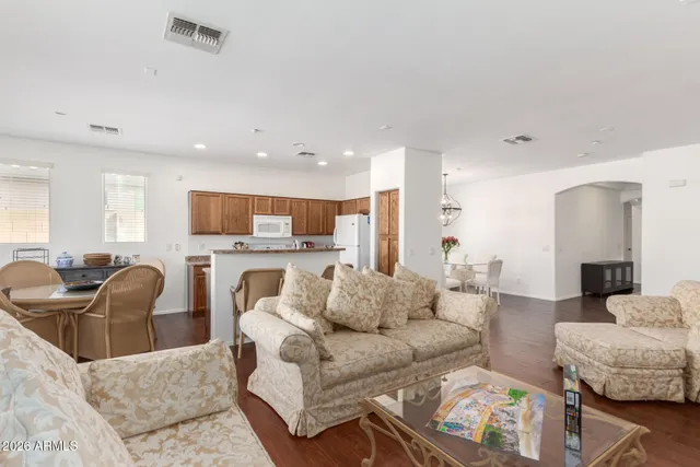 a living room with furniture kitchen view and a chandelier