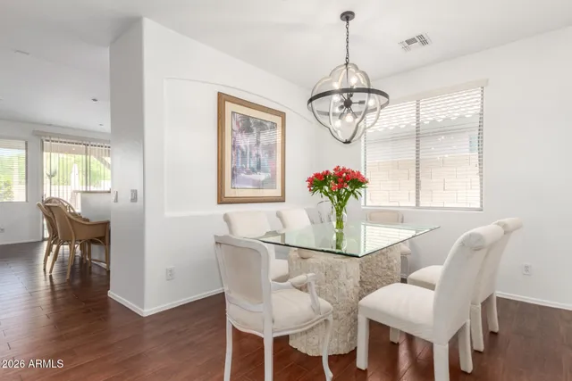 a dining room with furniture a chandelier and wooden floor