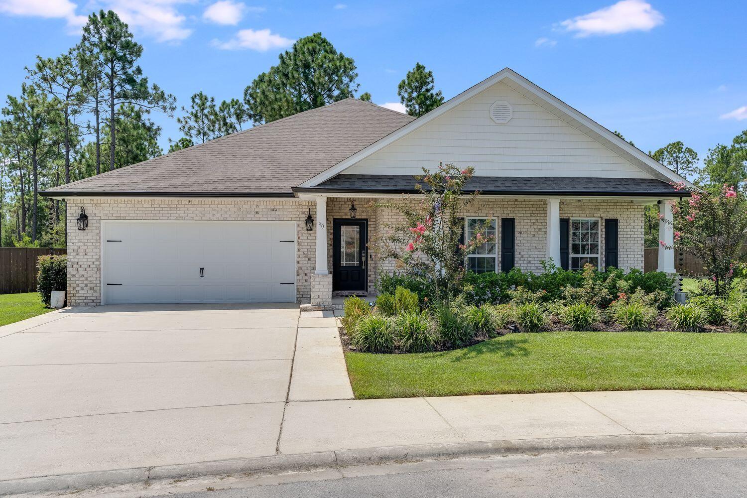 40 Bryant Road, Unit LOT 84 Santa Rosa Beach, FL 32459 - Photo 2 of 42 a front view of a house with a garden