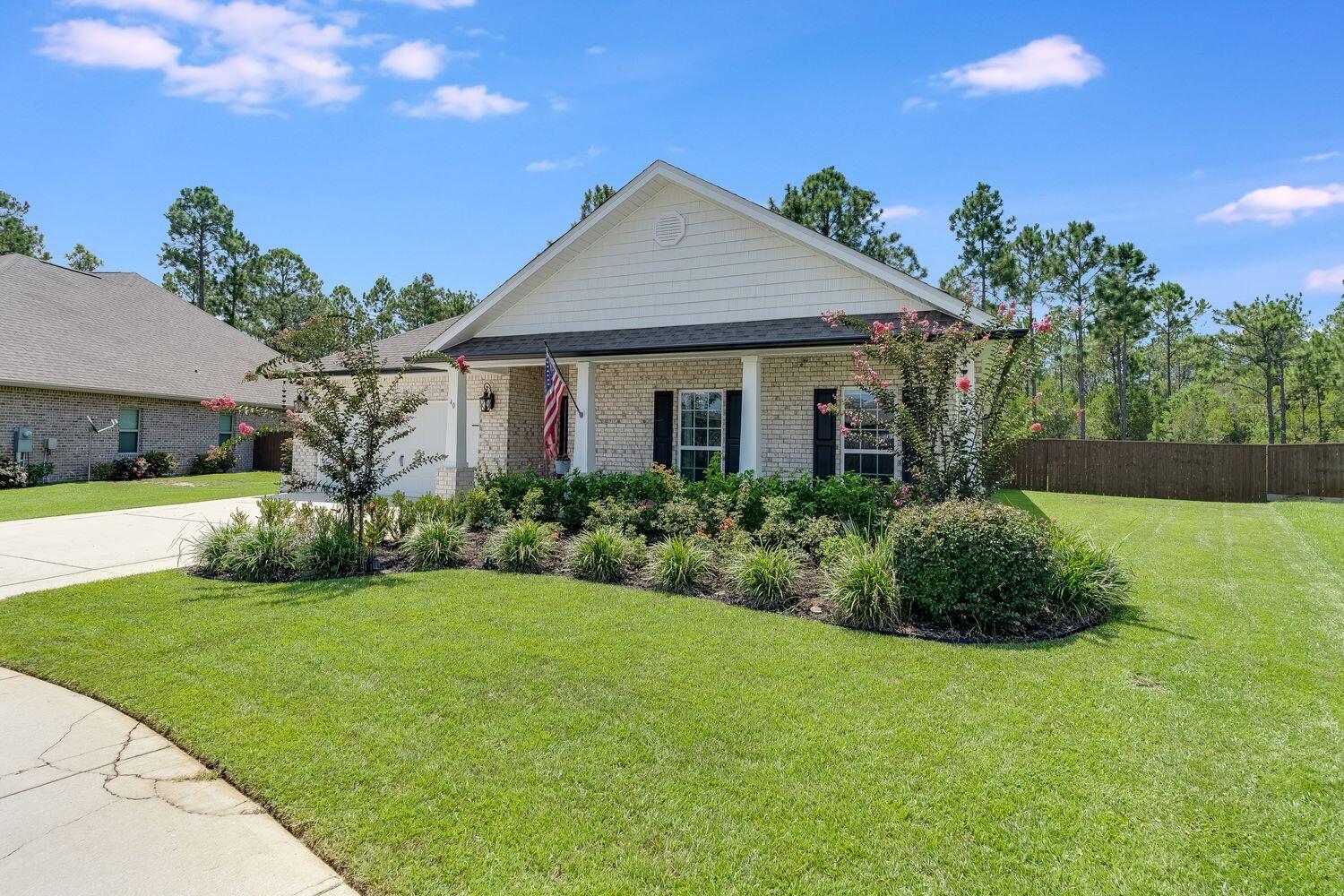 40 Bryant Road, Unit LOT 84 Santa Rosa Beach, FL 32459 - Photo 3 of 42 a front view of a house with a garden
