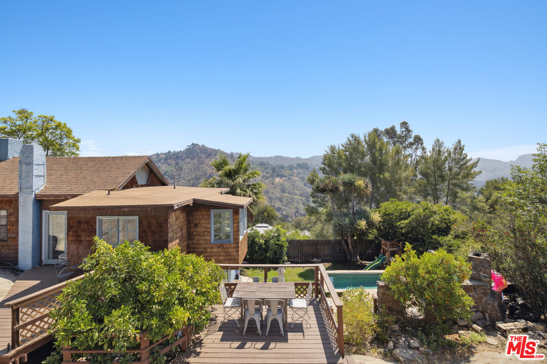 a view of a house with backyard garden and sitting area