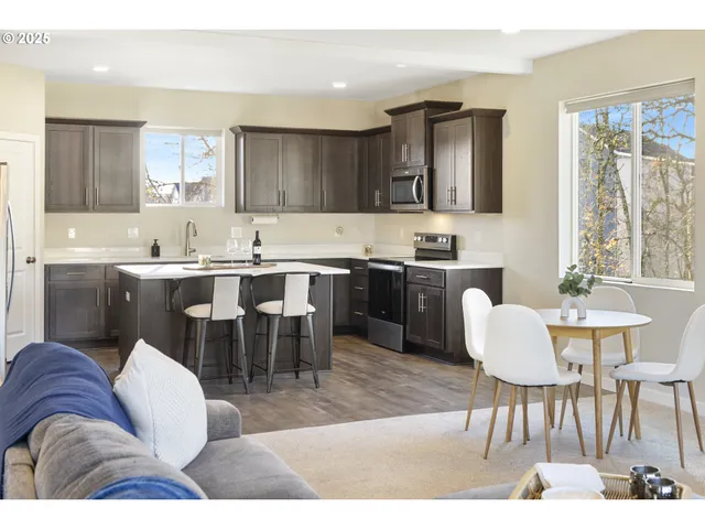 a living room with stainless steel appliances kitchen island granite countertop furniture and a large window
