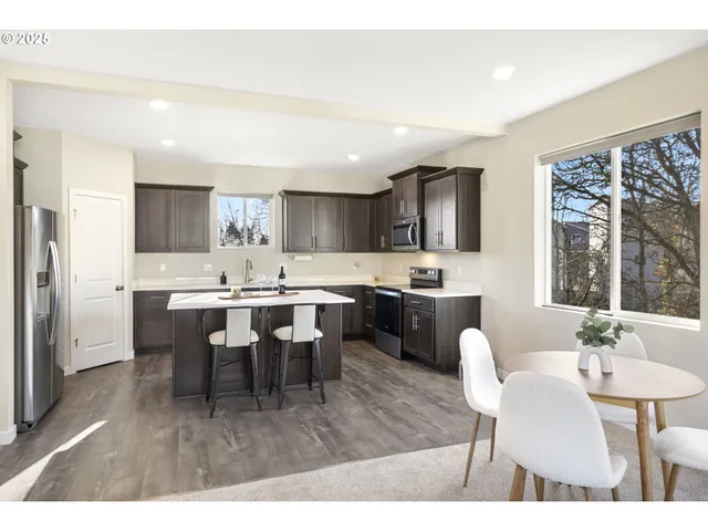 a kitchen with a dining table chairs and refrigerator