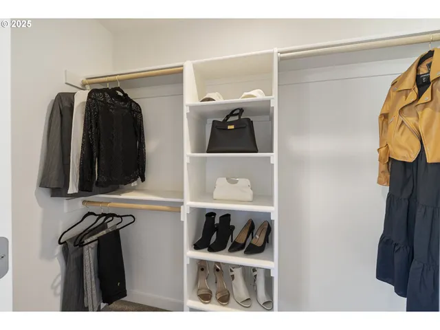 a view of walk in closet with clothes and shoes