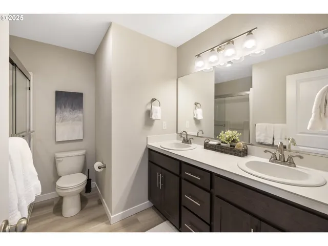 a bathroom with a double vanity sink toilet and a mirror